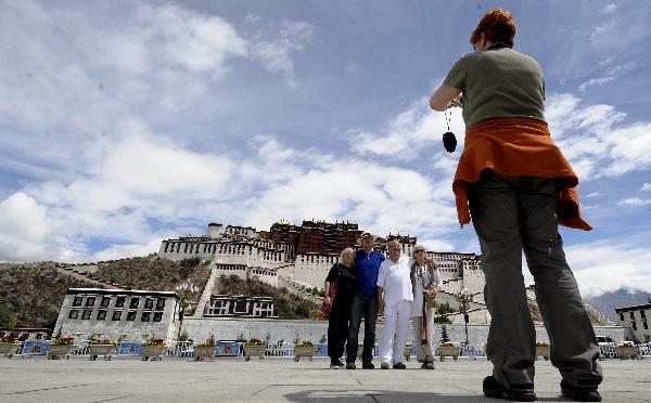 Quelques touristes étrangers font des photos de groupe sur la place du palais du Potala. Photo prise le 22 juin.