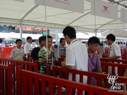s visiteurs tendent leurs billets de réservation pour vérification aux membres du personnel du pavillon chinois.