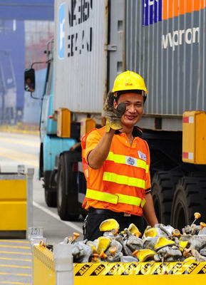 Un docker salue le journaliste en agitant sa main, sur le port de Yantian à Shenzhen. Le port de Yantian a été construit au début des années 80 du dernier siècle. En 2007, la capacité de chargement et de déchargement du quai à conteneurs international de Yantian a dépassé les 10 millions de conteneurs, la plus grande des ports de la partie continentale de la Chine depuis 4 années consécutives.