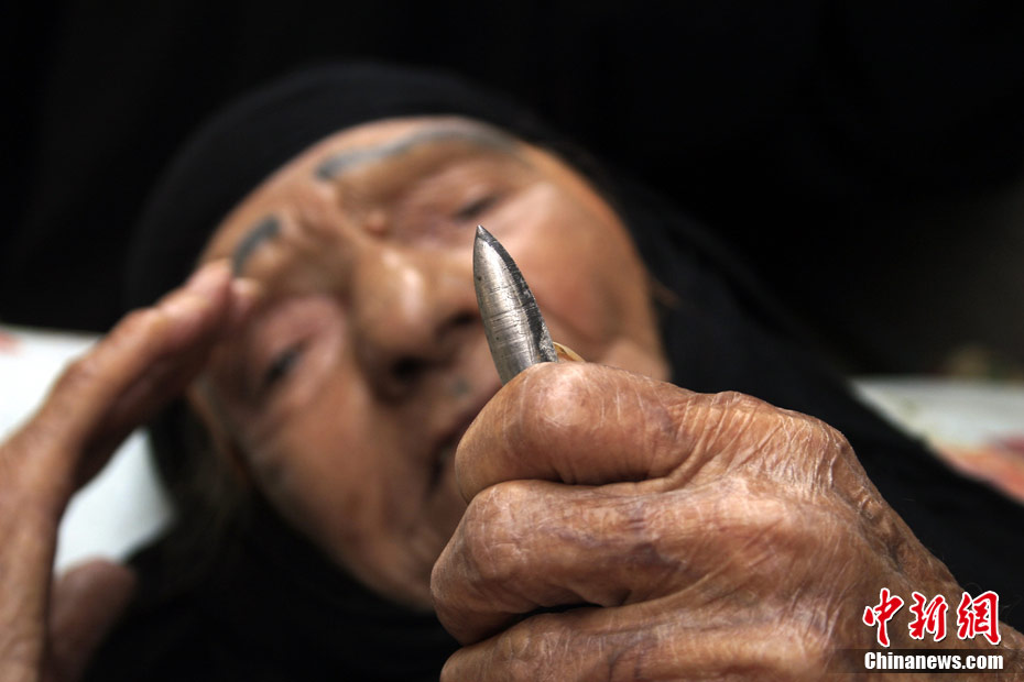 En juillet, une vieille femme irakienne regarde une balle après le combat. 