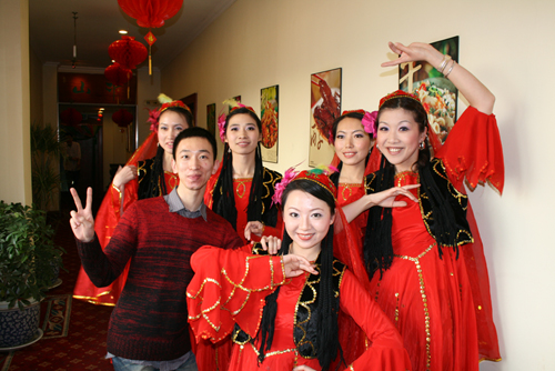 los miembros del departamento multilíngüe representan un baile típico xinjianés.