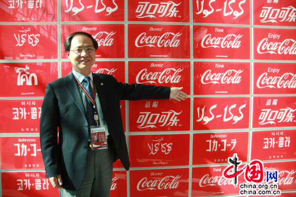 Les logos de Coca-Cola en différentes langues. M.Chen montre la version chinoise et la version en langue ouïgoure aux journalistes.