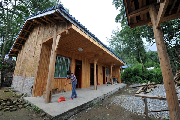 He Jiao nettoie sa nouvelle maison écologique à Daping (Sichuan), le premier essai d’écovillage à faible empreinte carbone de Chine.