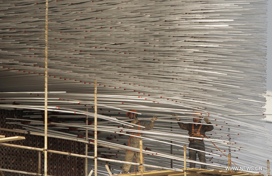 Des travailleurs démolissent les tubes en acrylique du pavillon du Royaume-Uni dans le parc de l&apos;Exposition universelle de Shanghai, le 8 décembre 2010. La démolition de quelque 60 000 tubes en acrylique sera terminée à la fin de l&apos;année.