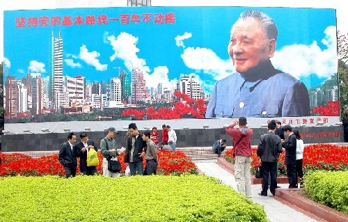 Le 11 avril 2004, des touristes prennent des photos souvenirs devant le portrait de Deng Xiaoping à Shenzhen. Haut de dix mètres et large de 30, ce portrait a été réalisé le 28 juin 1992. Plus d'un million de touristes posent avec le grand homme chaque année. 