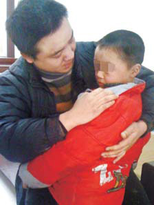Peng Gaofeng embrasse son fils de six ans dans la station de police de Pizhou, dans la province du Jiangsu. Le jeune garçon avait été enlevé le mars 2008 à Shenzhen.