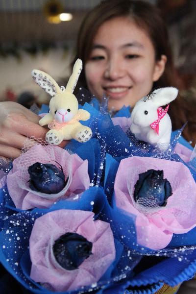 Une fleuriste prépare un bouquet de roses décoré de lapins en peluche dans une boutique de Lianyungang, dans la province orientale du Jiangsu.