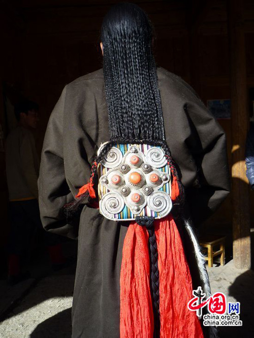 Les cheveux de la mariée, en deux rangs de tresses minuscules, supportent une lourde parure d&apos;argent ornée de pierres semi-précieuses. (Photo de Lisa Carducci)