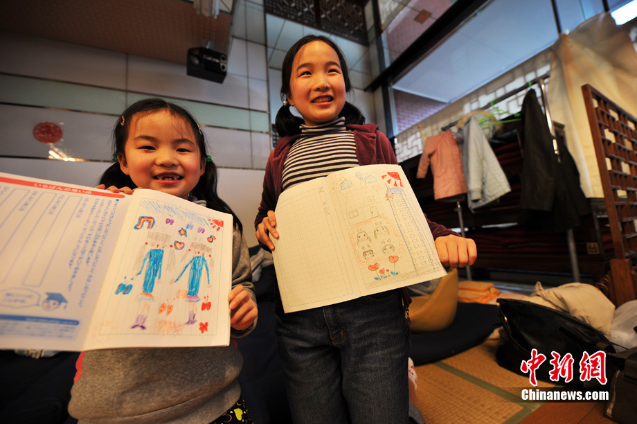 Les deux fillettes montrent leurs dessins ; la famille reste heureuse malgré l&apos;épreuve.