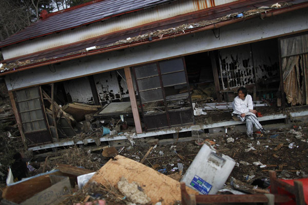 Katsuyuki Takahashi, assis près de la maison familiale où il est né, aujourd'hui détruite, à Kesennuma, dans la préfecture de Miyagi, 20 jours après la destruction de la région par un séisme de magnitude 9.0 et un tsunami, le 31 mars 2011.