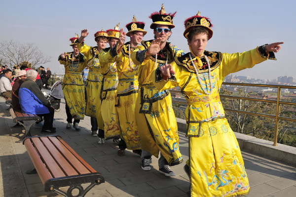 Des touristes étrangers revêtus de costumes de style Qing (1644-1911) dansent dans le parc Jingshan, situé au cœur de Beijing, le mois dernier. Des touristes étrangers revêtus de costumes de style Qing (1644-1911) dansent dans le parc Jingshan, situé au cœur de Beijing, le mois dernier.
