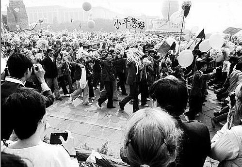 « Bonjour, Xiaoping ». Le 1er octobre 1984, pour célébrer le 35e anniversaire de la République populaire de Chine, un défilé est organisé sur la place Tian'anmen. Les étudiants de l'Université de Beijing portent une banderole pour saluer Deng Xiaoping.