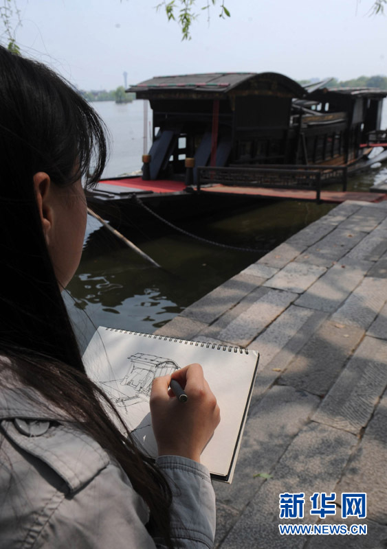 Une fille esquisse un croquis du bateau « rouge ».