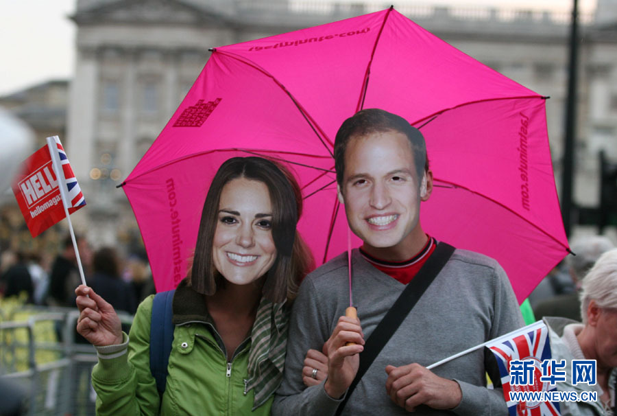 Le 28 avril à Londres, deux touristes portent des masques à l'effigie du prince William et de Kate Middleton.