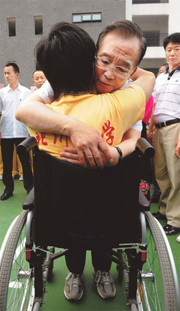 Le Premier ministre Wen Jiabao étreint Zheng Haiyang, un élève du collège de Beichuan dans la province du Sichuan, lors de sa visite sur place dimanche. Les deux jambes du jeune garçon ont dû être amputées pour le sauver après le séisme du 12 mai 2008.
