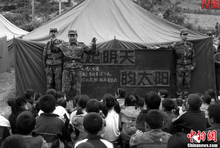 Le 20 mai 2008, un soldat de l&apos;APL donne un cours de musique aux enfants près d&apos;une tente.