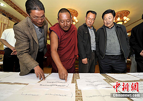 Les membres du jury et les moines admirent les œuvres calligraphiques.