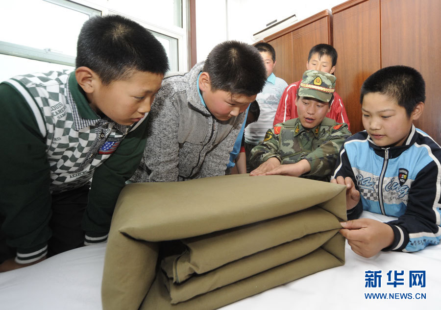 Le 30 mai, des enfants apprennent à plier une couverture ouatée à Tangshan, ville de la province du Hebei.