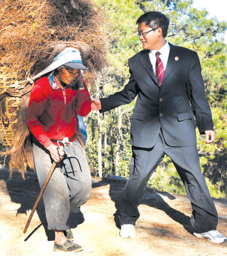 Long Jinpin, 39 ans, juge dans le district de Nanjian, province du Yunnan, bavarde avec une femme de l'ethnie yi, alors qu'il va résoudre des différends légaux dans des villages de montagne, le 25 février. 