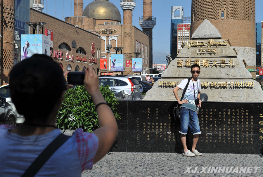 Un touriste pose devant le grand bazar international du Xinjiang. Photo prise le 4 juillet.