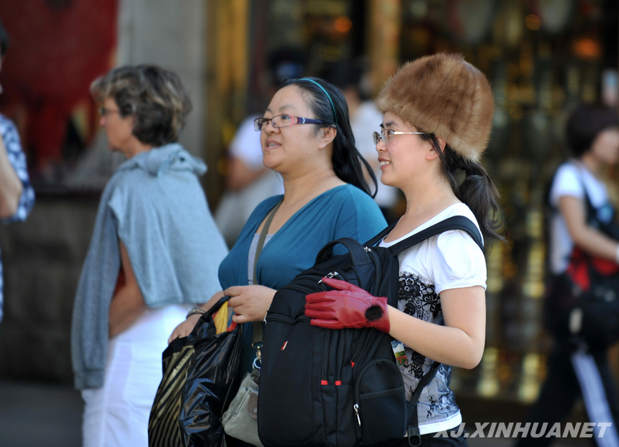 Une touriste porte un bonnet de fourrure et des gants de cuir qu'elle vient d'acheter dans le grand bazar. Photo prise le 4 juillet.