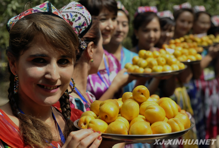 Le 30 juin, des filles ouïgoures invitent les passants à goûter des abricots.