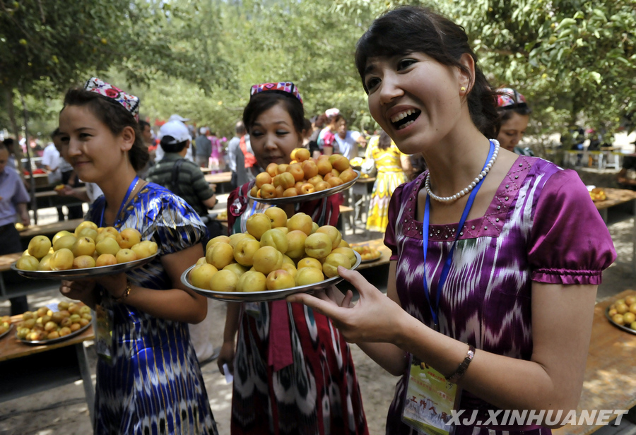 Le 30 juin, des filles ouïgoures invitent les passants à goûter des abricots.