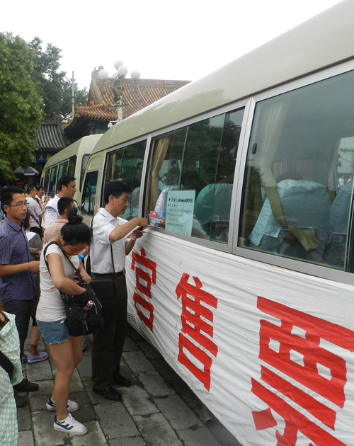 Le 20 juillet, des touristes font la queue devant la voiture de billetterie.