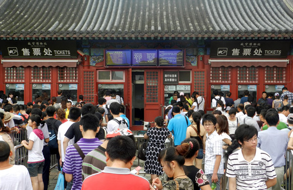 Le 20 juillet, des touristes font la queue devant le guichet de la Cité interdite pour acheter des billets.