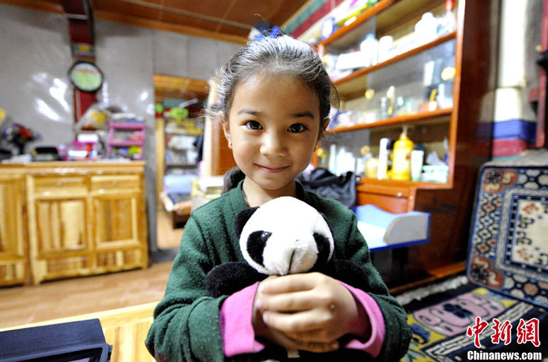 Zhuoma tient son panda en peluche.