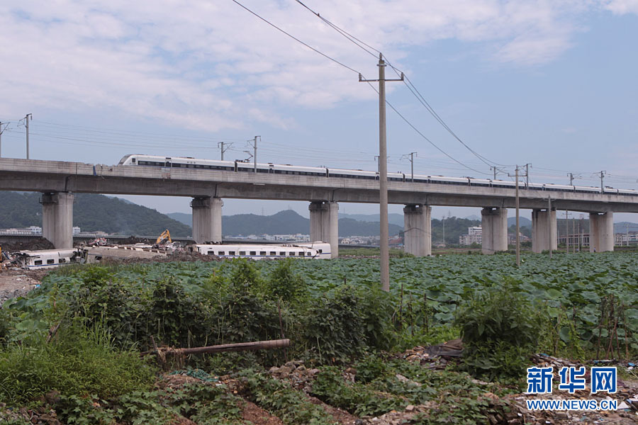 Un train passe lundi matin sur le site de l'accident meurtrier qui a eu lieu samedi dans la province du Zhejiang (est).