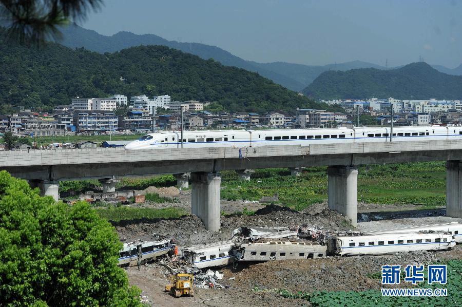 Un train passe lundi matin sur le site de l'accident meurtrier qui a eu lieu samedi dans la province du Zhejiang (est).