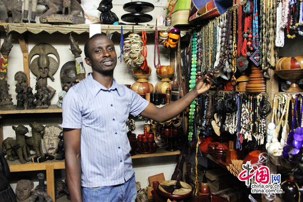 Mohomed Garba, propriétaire d&apos;une boutique sur le marché, montre ses produits aux clients.