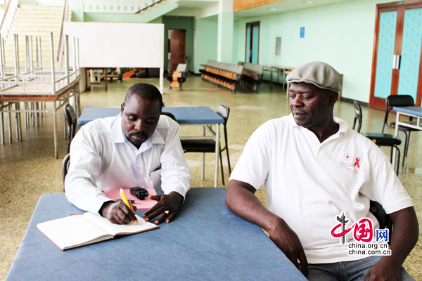 Deux techniciens camerounais se reposent dans le hall du Palais des congrès de Yaoundé.