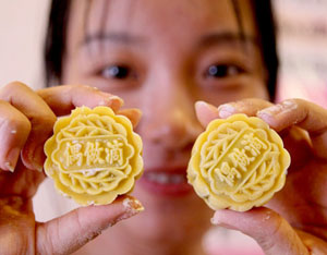 Une femme montre deux gâteaux de lune qu'elle vient de réaliser dans son atelier de Shenyang, dans la province septentrionale du Liaoning, le 4 septembre 2011.