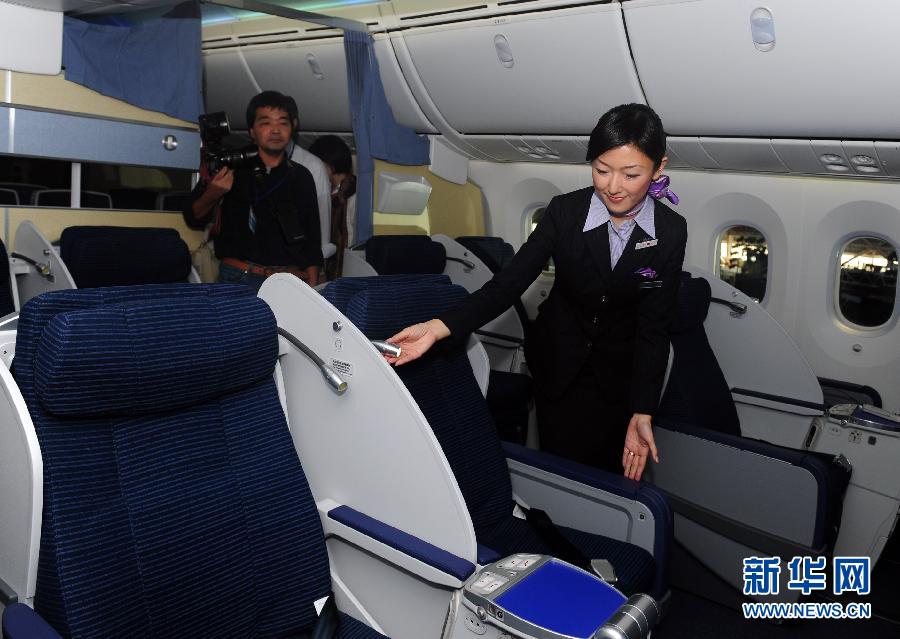 Une hôtesse explique les fonctionnalités des sièges de première classe du Boeing 787.