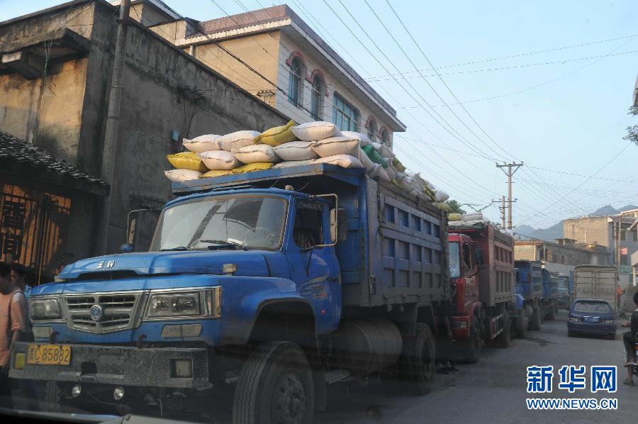 Des camions transportant le sorgho passent à intervalles réguliers dans le bourg de Maotai dans la province du Guizhou.