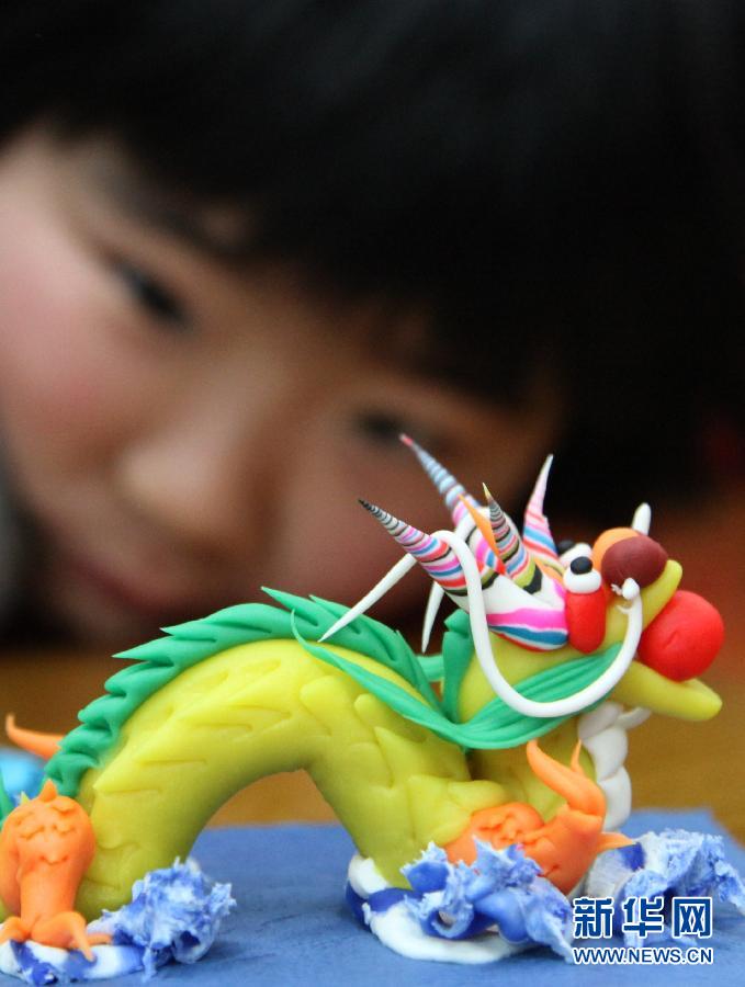 Le 20 janvier, une jeune fille observe un modelage de dragon dans une bibliothèque de Nanjing.