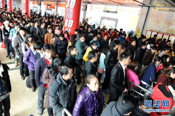 Le 26 janvier, dans le district Xuan'en du Hubei, les passagers font la queue pour acheter des billets de bus.