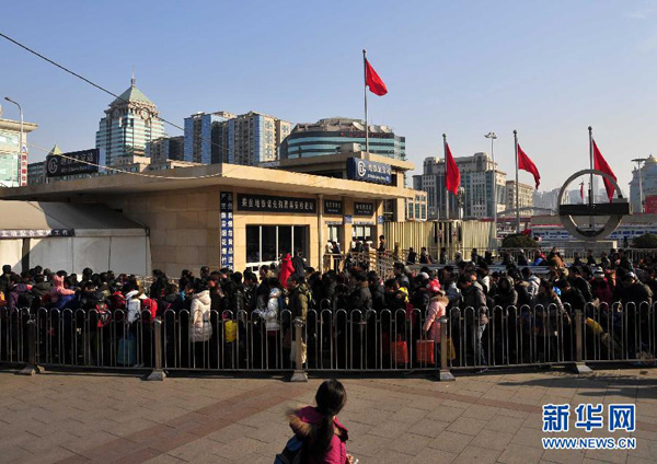 Le 26 janvier devant la Gare de Beijing, les passagers font la queue pour prendre le métro.