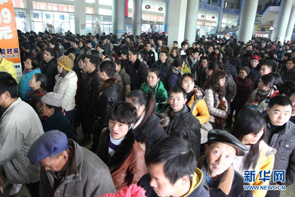 Le 26 janvier, dans le district Renshou de la province du Sichuan, les passagers font la queue pour acheter des billets de bus.
