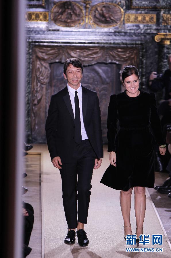 Le 25 janvier, les stylistes italiens Maria Grazia Ghiuri (à droite) et Pier Paolo Piccioli saluent les spectateurs lors du défilé de la collection printemps/été 2012/2013 de la marque italienne Valentino à Paris.