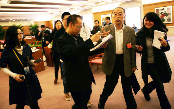 Le 4 mars, Wang Jianxi, directeur général adjoint et directeur des risques du CIC et membre du Comité national de la Conférence consultative politique du Peuple chinois, est entouré des journalistes au Centre de conférence de Beijing