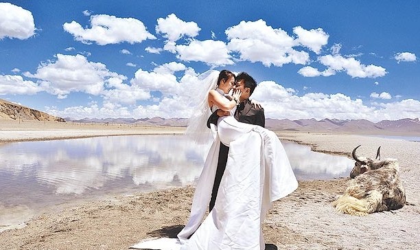 Le futur marié prend son épouse dans les bras au bord du lac Namco, à une altitude de 4700m.