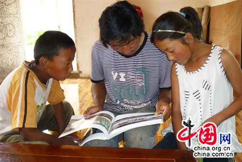Les jumeaux de la famille et leur cousin regardent un livre sur le Zhejiang
