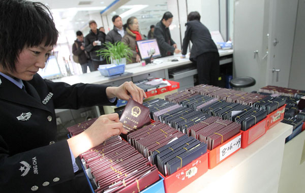 Une policière examine les passeports des demandeurs à Beijing, le 19 octobre 2012.