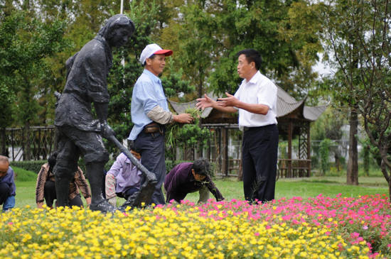 Le délégué au 18e Congrès du Parti communiste chinois, Chang Desheng, discute avec des jardiniers du village de Jiangxiang, dans la municipalité de Changshu au Jiangsu, le 23 août 2012.