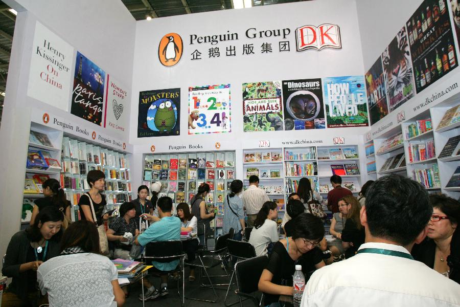 Le 31 août 2011, les visiteurs discutent affaires lors de l&apos;Exposition du livre de Beijing. 