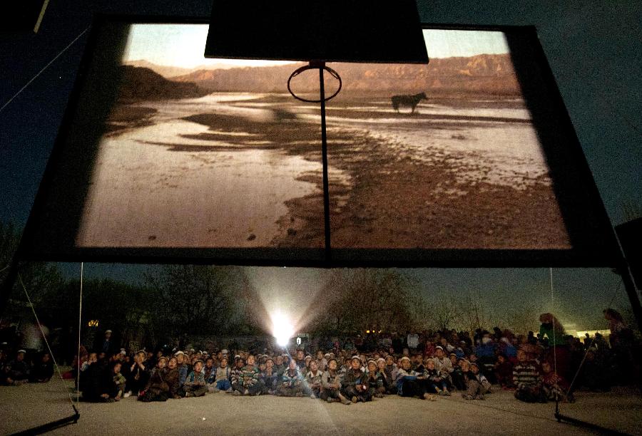 Le 15 avril 2011, les habitants regardent un film dans un village de la région autonome ouïgoure du Xinjiang.