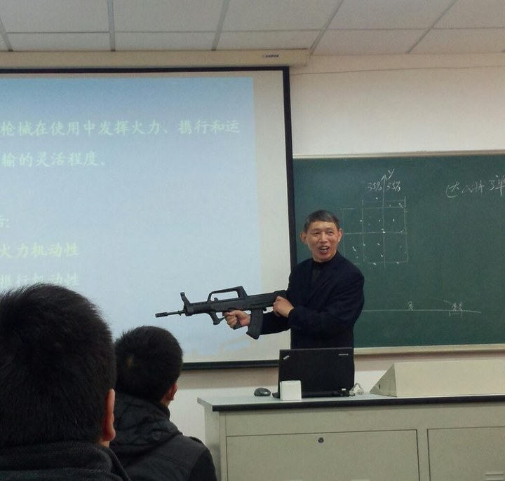Un professeur chinois apporte un fusil AK-47 au cours